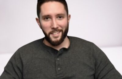Jared Carrabis smiling while hosting a baseball sports show.