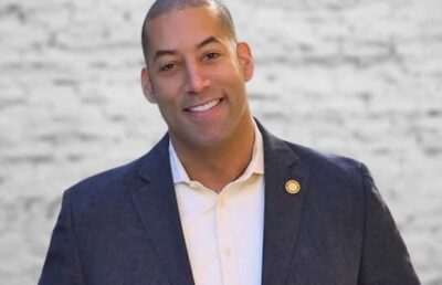 A photograph of Sean Spiller wearing a suit with a confident smile.