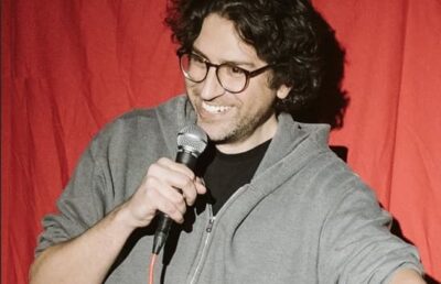 David Angelo performing stand-up comedy at a New York City venue in 2025