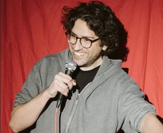 David Angelo performing stand-up comedy at a New York City venue in 2025