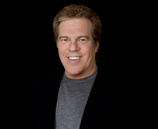 Jeff Margolis smiling in a black blazer and grey shirt, known for producing the Oscars and Emmy Awards
