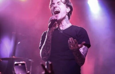 Jordan Lutes performing live in 2025 with edgy fashion and tattoos visible.