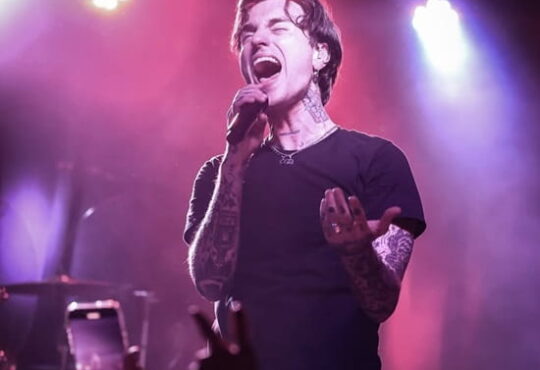 Jordan Lutes performing live in 2025 with edgy fashion and tattoos visible.